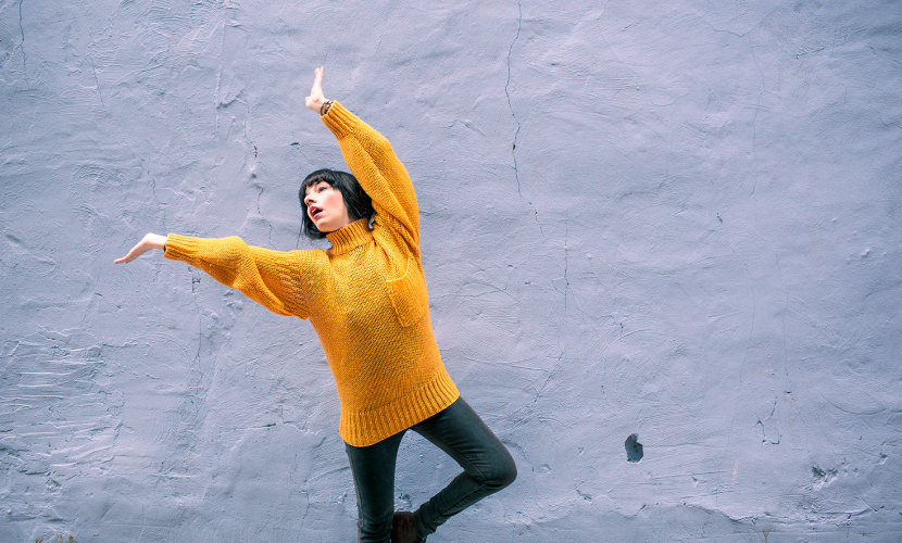 a woman poses against a wall